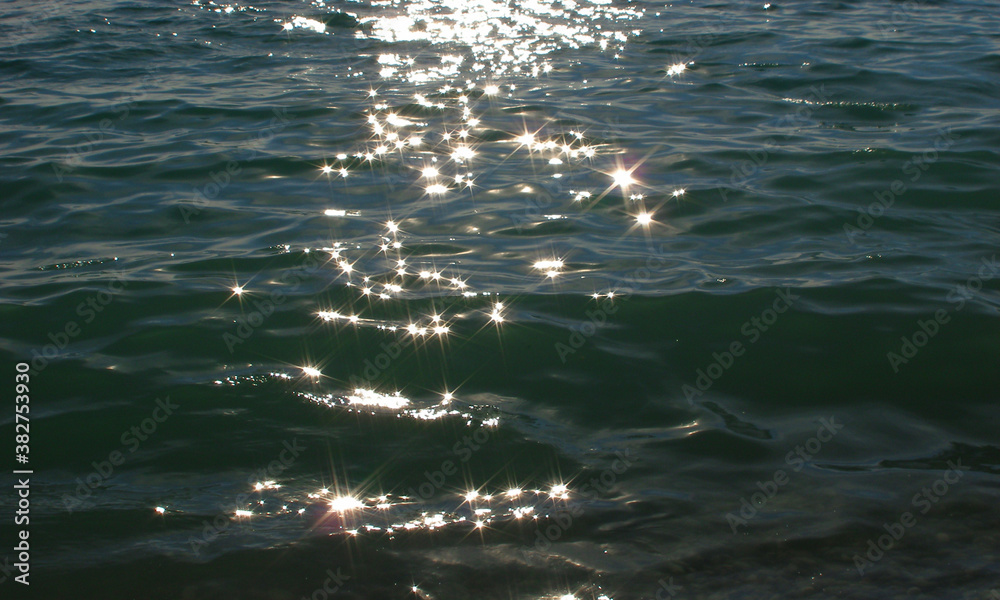beautiful sparkling background glare on the surface of the water like ...