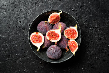 Wall Mural - Fresh whole and sliced fig on black background, top view