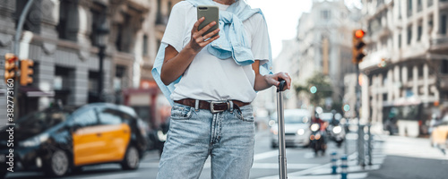 Fotomural Young traveling woman with suitcase on a sunny city street