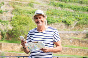 tourist with map and mobile phone in the field