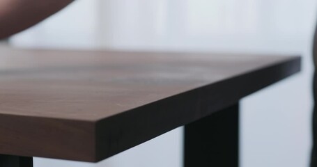 Poster - Slow motion of man hand sanding toned walnut table surface before applying finish