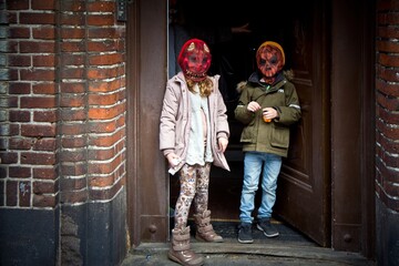 copenhagen, denmark - october 12, 2015. two children in jackets and halloween masks of monsters stan