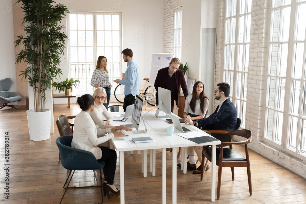 Multiethnic diverse colleagues work in shared modern loft office ...
