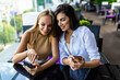 © F8  \ Suport Ukraine - Two friends women enjoying coffee together in a coffee shop and using phone