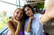 © F8  \ Suport Ukraine - Two smiling women friends driniking coffee and taking selfie, friendship concept