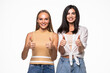 © F8  \ Suport Ukraine - Portrait of two young women friends gesturing thumbs up over white background