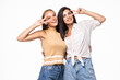 © F8  \ Suport Ukraine - Two playful girls standing together and showing peace gestures while looking at the camera over white background