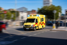 A Yellow Ambulance With Blue Lights Going At High Speed On The Street