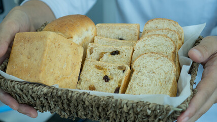 Chef hold wicker basket inside bread homemade with two hands.