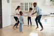 © fizkes - Full length overjoyed african american couple jumping with joyful energetic children siblings barefoot on warm kitchen floor, celebrating freedom weekend or enjoying stress free leisure active time.