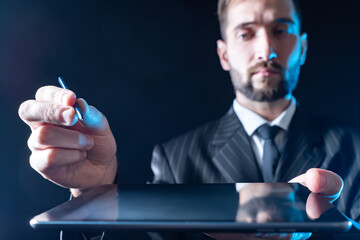Poster - man uses an electronic tablet. hands of a person with an electronic tablet and a stylus close-up. th
