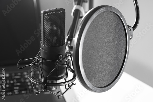 Black and white photo of a Studio microphone with a pop filter and vibration protection. Voice recording. Recording equipment. Equipment of the recording Studio.