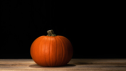 Wall Mural - Pumpkin on old dark rustic wooden table. Halloween background with pumpkin. Autumn, Halloween concept. Copy space.