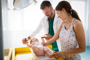 Wall Mural - Happy beautiful mother and little baby on medical examination in pediatrician office