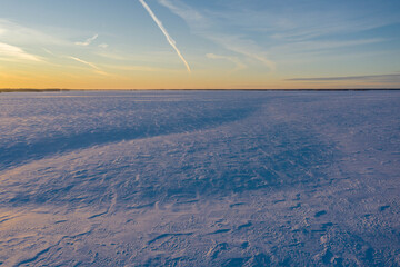 Drone shot. Frozen snow field at sunset background