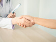 © phoomrat - female doctor shacking patient hand after giving advice or doing health examination or medical checkup in hospital with white background and copy-space.