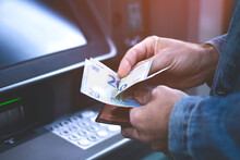 Unrecognizable Man Counting Euros Withdrawn From ATM. Man Withdraws Cash From Bank.