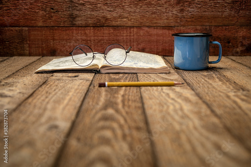 Fotografía Vintage expedition journal on a rustic picnic table with a cup of tea - handwriting and drawing in travel log (property release attached), selective focus
