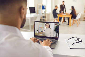 Company worker sitting in office and having online meeting with director, client, coach or colleague