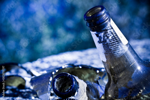 Fotografía Shattered beer bottle resting on the ground: alcoholism concept - toned image