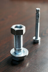 A lot of metal bolts, nuts and washers. Bolts are for the assembly of two unthreaded components, with the aid of a nut. Screws in contrast are used in components which contain their own thread.