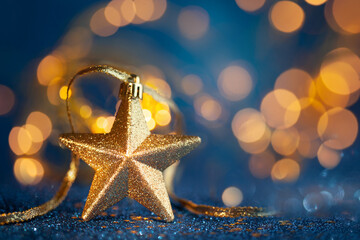 Festive  Golden Christmas Star with blurred gold lights background. Christmas or New Year concept with copy space.