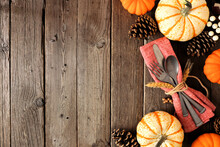 Autumn Harvest Or Thanksgiving Table Scene With Silverware, Napkin, Pumpkin And Decor Border Against A Rustic Dark Wood Background. Copy Space.