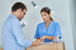 © Kalim - Patient signing documents in dental clinic