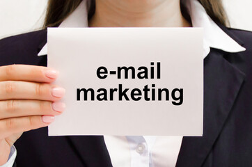 e-mail marketing is written on a white card held by a man in a suit