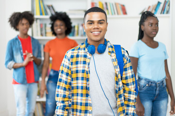 Wall Mural - Laughing brazilian male college student with braces and group of other young adults