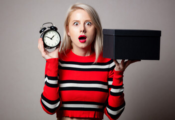 Wall Mural - Style blonde in red sweater with alarm clock and gift box