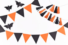 Halloween Background With Garlands And Paper Bats In Traditional Colors Orange And Black On White Background With Copy Space