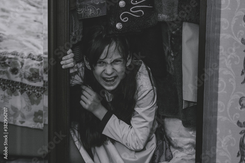 Fotomural Mad scary girl in cupboard at dark night
