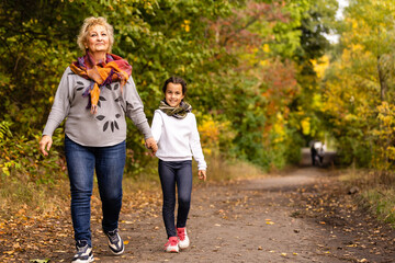 Portrait of grandmother and granddaughter in autumn park