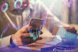 © peshkova - Double exposure of man's hands holding and using a phone and financial graph drawing. Analysis concept.