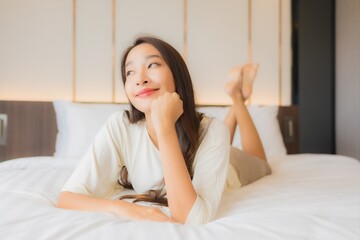 Wall Mural - Portrait beautiful young asian woman smile relax on bed in bedroom interior