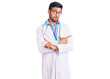 Young hispanic man wearing doctor uniform and stethoscope pointing to both sides with fingers, different direction disagree