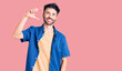 © Krakenimages.com - Young hispanic man wearing casual clothes smiling and confident gesturing with hand doing small size sign with fingers looking and the camera. measure concept.