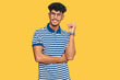 © Krakenimages.com - Young arab man wearing casual clothes and glasses with a big smile on face, pointing with hand and finger to the side looking at the camera.