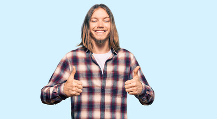 Wall Mural - Handsome caucasian man with long hair wearing hipster shirt success sign doing positive gesture with hand, thumbs up smiling and happy. cheerful expression and winner gesture.