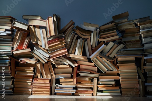 Cuadros en Lienzo Pile of old books in dramatic dim light sunlight rays through window