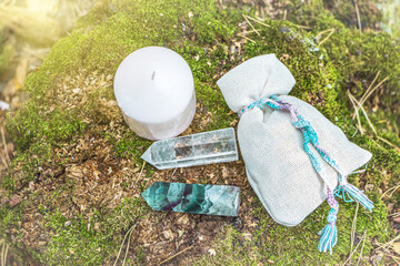 Wall Mural - Magic still life with fluorite, quartz crystal, candle and bag with potion (herb). Rocks for mystic ritual, witchcraft Wiccan or spiritual healing on stump in forest. Ritual for love.