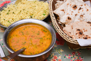 Spicy dal fry, dhal curry and Roti popular traditional North or South Indian vegetarian food in mud, clay pot Kerala India. Side dish of chapati, chapathi, paratha, puri, rice. split pea, lentil soup