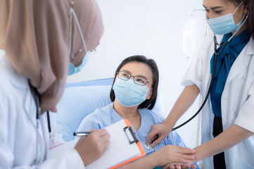 The young female Muslim physicain exam, check-up, and take care fo the elderly female patient