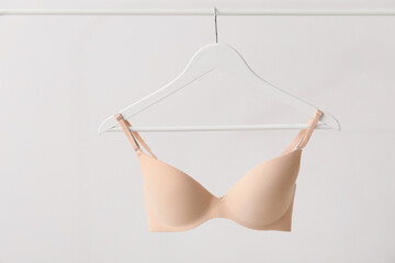 Wall Mural - Hanger with stylish bra on light background
