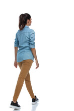 Side Rear View Of Smart Casual Woman Walking, Wearing Shirt
