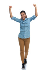Wall Mural - smart casual woman celebrating with hands in the air, smiling