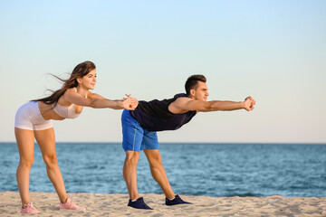 Sporty young couple training on sea beach