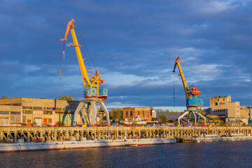 Port cranes on sunset