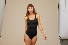 Woman In A Bodysuit Smiling On Brown